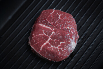 Raw aged Angus steak, fried in a cast-iron pan. Fluted frying pan.