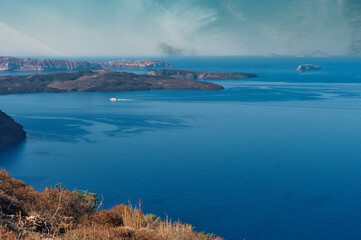 Beautiful landscape with sea view. Cruise liner at the sea near the Nea Kameni, a small Greek island in the Aegean Sea near Santorini, cyclades, Greece