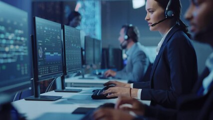 Happy Beautiful Technical Customer Support Specialist Having a Headset Call while Working on a Computer in a Dark Monitoring and Control Room Filled with Colleagues and Display Screens. - Powered by Adobe