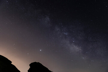 Fototapeta premium The milky way over the canyon in the desert
