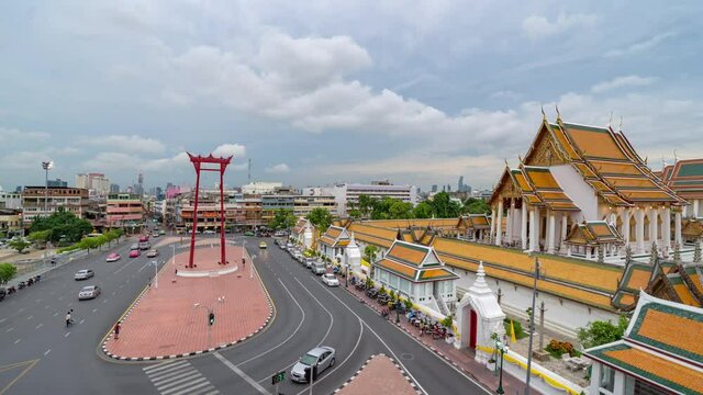 Time lapse. The Giant Swing or Sao Ching Cha monument with Wat Suthat temple at sunset in old town, Bangkok City, Thailand. Landmark tourist attraction. Thai architecture with travel trip concept.