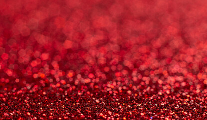 Red festive Christmas background. Abstract shimmering bright background with bokeh defocused red lights. Shiny gradient with copy space. Ruby wedding, new year, valentine's day concept. Glitter