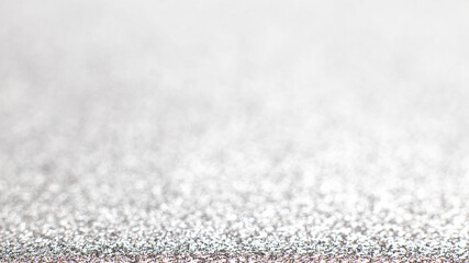 Silver festive Christmas background. Abstract shimmering background with bokeh silver lights. Shiny gradient with copy space. Silver wedding, new year concept. Selective focus. Glitter