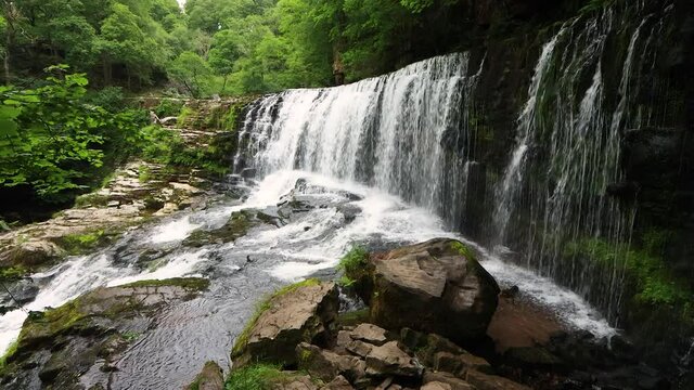 4K footage of a beautiful waterfall (Sgwd Isaf Clun-gwyn) in the Brecon Beacons, Wales, UK