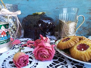 Still life ceramic brown elephant for dry tea cup holder roses cookies with jam glass on the lace tablecloth