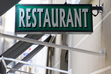 restaurant text sign green on french building city street