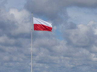 on flagpole the red and white flag of Poland is waving