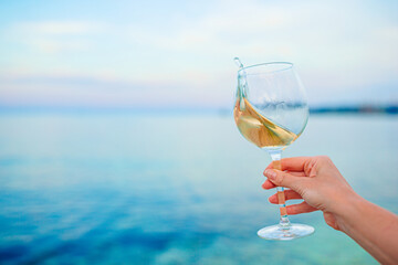 Glass of white wine on tropical beach