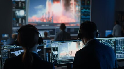 Flight Director Counts Down the Seconds Before Space Rocket Launch. Team in Mission Control Witness Successful Lift Off. Flight Control Employees Sit in Front of Computers and Monitor the Mission.