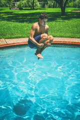 Teenager jumping into swimming pool on a sunny day
