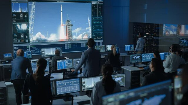 Group of People in Mission Control Center Witness Successful Space Rocket Launch. Flight Control Employees Sit in Front Computer Displays and Monitor the Crewed Mission. Team Stand Up and Clap Hands.