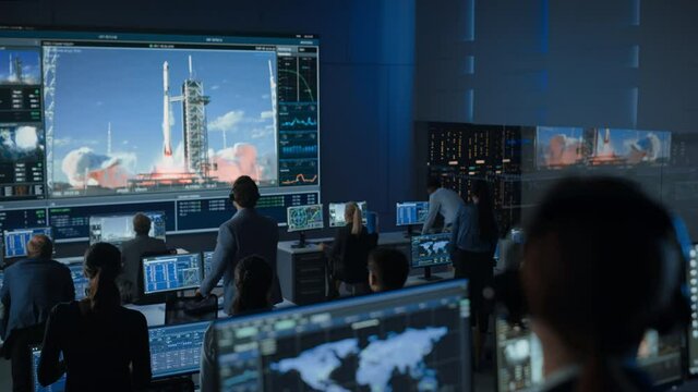 Flight Director Counts Down the Seconds Before Space Rocket Launch. Team in Mission Control Witness Successful Lift Off. Flight Control Employees Sit in Front of Computers and Monitor the Mission.