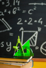 Back to school concept with books and colorful Stationery over black chalkboard. School times....