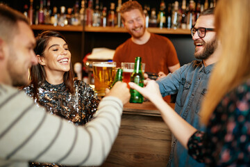 Group of friends drinking beer, chatting and having fun at pub.