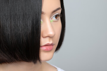Portrait of a beautiful teenage girl with dark hair, with beautiful creative white-green makeup and healthy clean skin.  Makeup and cosmetology concept.