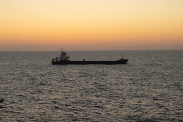 cargo ship going at sunset