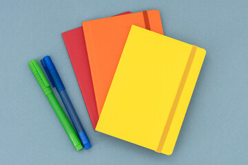 Notepads, eraser and colorful pencils on the blue background.