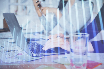 Multi exposure of woman hands typing on computer and forex chart hologram drawing. Stock market analysis concept.
