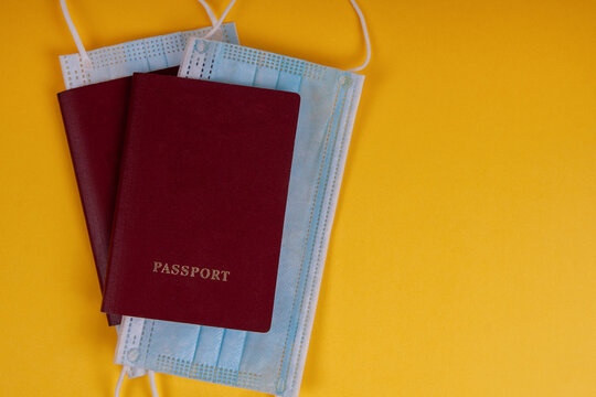 Passports with masks on a yellow background. Concept vacation or business trip during a pandemic.