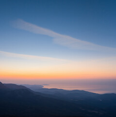 mountain chain above a sea bay before a sunrise, early morning sea scene