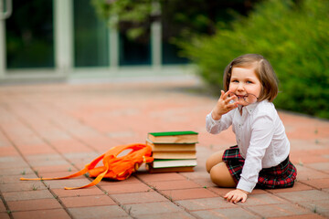 Little girl in school uniform and glasses, with textbooks