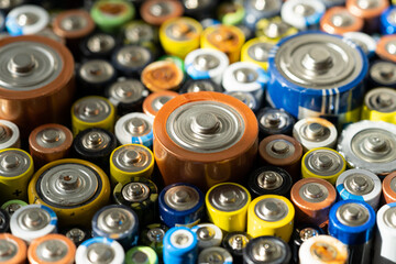 Fototapeta Close up of positive ends of discharged batteries of different sizes and formats, selective focus. Used battery for recycling. Hazardous garbage concept obraz