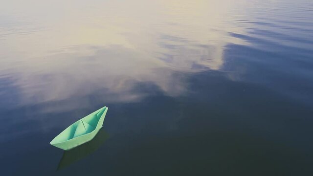bluei paper sailboat sailing on water. River, lake, sea.
