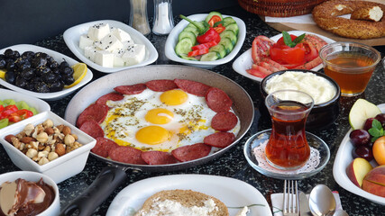 Traditional Turkish Breakfast with sausage egg pan on granite marble table.Close and large view        
