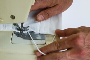 Surgical face mask is sewn on the sewing machine,close up