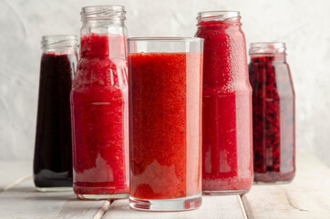 Glass jars with different smoothies with fresh berries