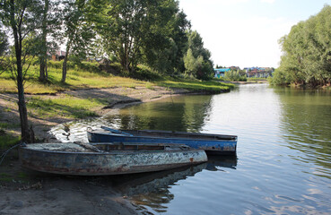 old boats on the river Bank in the summer in a Siberian village