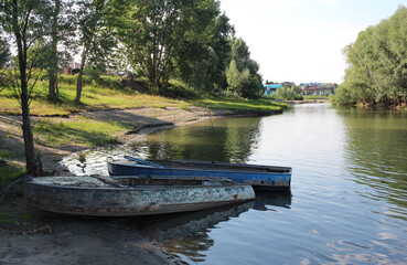 Fototapeta premium old boats on the river Bank in the summer in a Siberian village