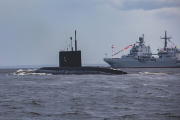 A line of modern russian military submarine cruisers in the row, northern fleet and baltic sea fleet in the open sea, submarine during military exercise