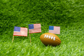 American football soccer with flag of America on green grass