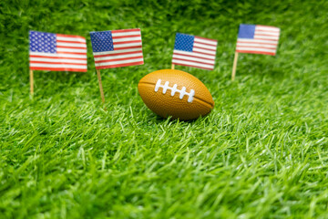 American football soccer with flag of America on green grass