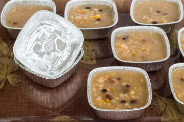 Traditional Turkish Dessert Asure on tray with ladle and aluminum bowls,foil containers.Take away food.