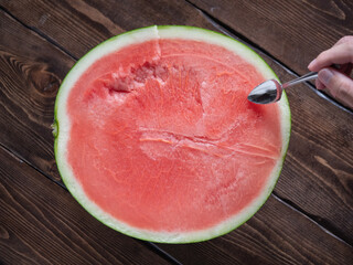 半分にカットしたスイカにささるスプーン。