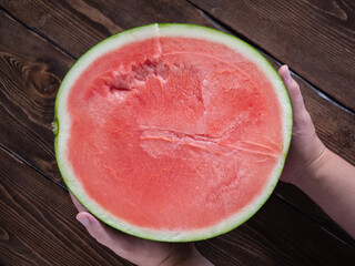 人の手で持った、カットした大きなスイカ。