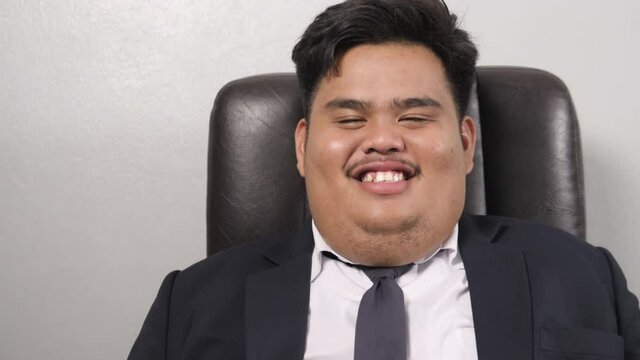 A funny Asian fat business man wearing a suit like the head of corporate executive  are laughing heavily.