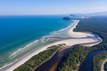 Foto aérea do encontro da água do rio com o mar. Praia de Guaratuba e Rio Itaguaré. Curvas e formas do rio. Linda imagem da junção do rio com a praia em meio a natureza preservada. 