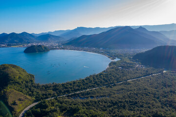 Fototapeta na wymiar Paisagem captada com drone incluindo linda praia paraalela com a rodovia e montanhas.