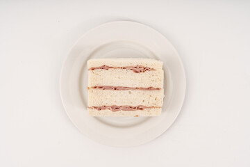 Sandwich made by white bread, ham and mayonnaise on white background.