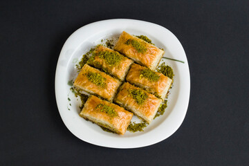 Traditional Turkish Pastry Dessert,Pistachio Baklava in plate at black surface with copy space..
