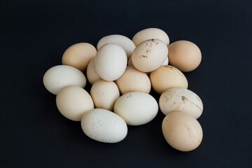 Organic,fresh large size uncooked eggs on black background with copy space.Hand holding.