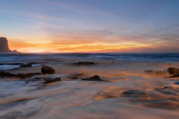 Water flowing around the rocks at dawn.