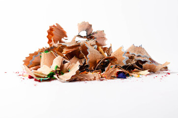 Shavings of red pencil in close-up on a white background. Pencil lead whole and broken on a white background. Leftovers from a pencil. Macro, a pile of shavings