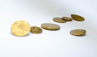 Ukrainian coins on a white background in close-up. Coins in a heap close-up, in the form of a falling pyramid, in a man's hand