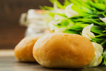 A hamburger bun sits on a wooden textured table, close up.