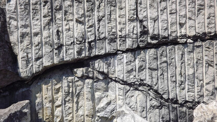 a fragment of grey rock with traces of processing