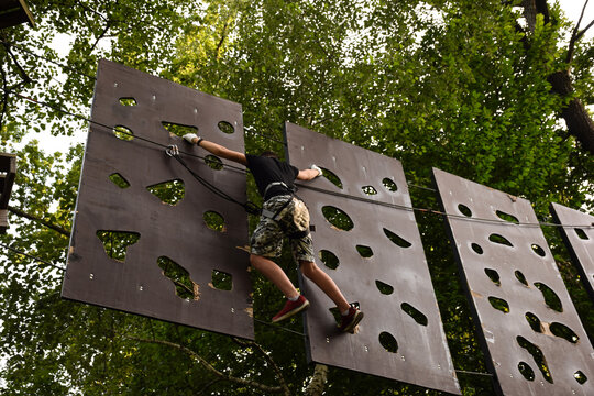 The guy goes through the obstacle course on the rope park